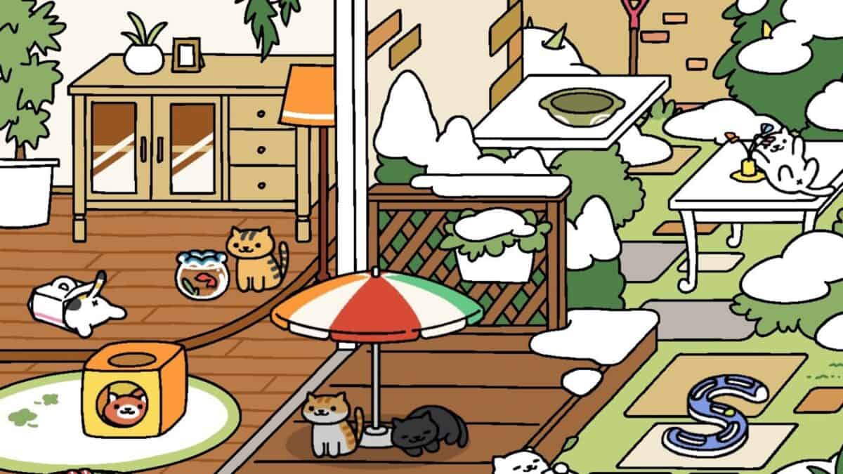 Cats lounging and playing in a snowy backyard with various toys, a garden table, and a small structure, reminiscent of cozy mobile games. Some snow is visible on the ground and objects.