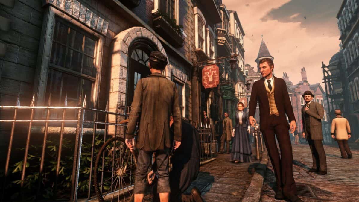 People dressed in Victorian-era clothing stand and walk along a cobblestone street lined with old buildings.