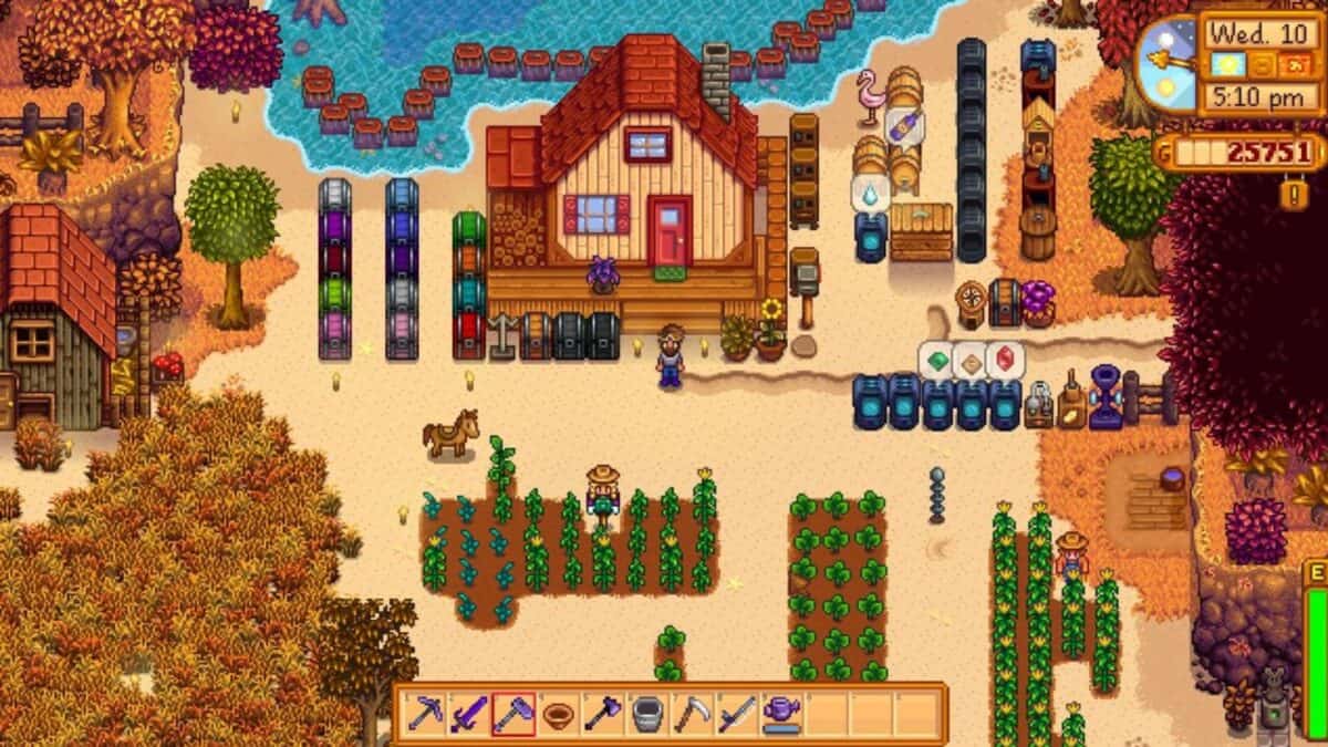 A player stands on a beach farm in Stardew Valley, surrounded by crops, barrels, chests, and sheds, with a farmhouse in the center and the sea at the top of the image.