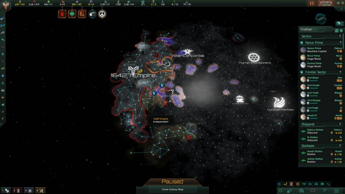 A paused Stellaris game screen displays a galaxy map with various colored empires, borders, fleet icons, and a partially explored region in the center. Game interface elements are visible.