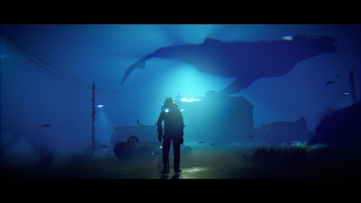 A person in a diving suit stands underwater near a house and car, looking up at a large whale swimming overhead.