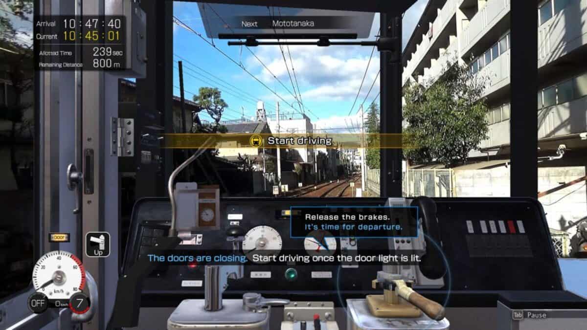 View from a train simulator cockpit showing controls, gauges, and instructional prompts to release brakes and start driving. Train tracks and urban scenery visible through the front window.