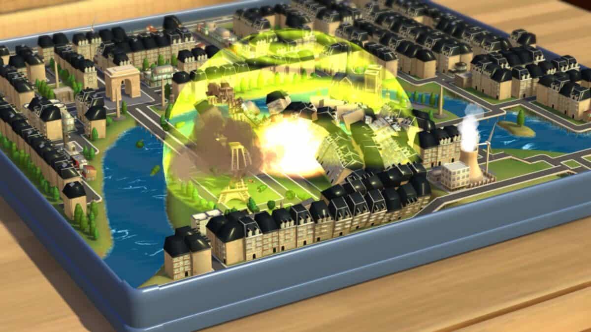 A tabletop model city is hit by a large explosion at its center, with buildings and streets arranged around a river in a grid layout.